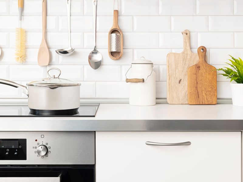 Cooking concept close-up of kitchen stove with saucepan and cooking utensils